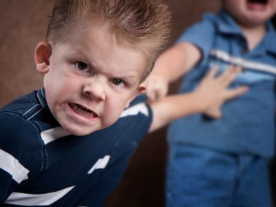 Angry little boy glaring and fighting with his brother